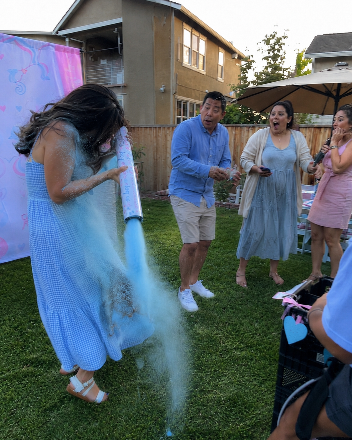 A pregnant mum's gender reveal cannon misfires, blowing blue powder downward onto her dress instead of into the air