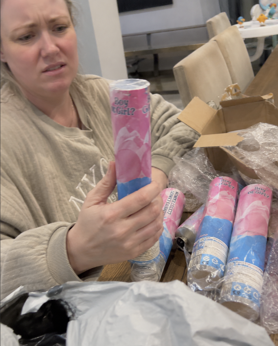 A pregnant mum unboxing a cheap imported gender reveal cannon with a sceptical expression